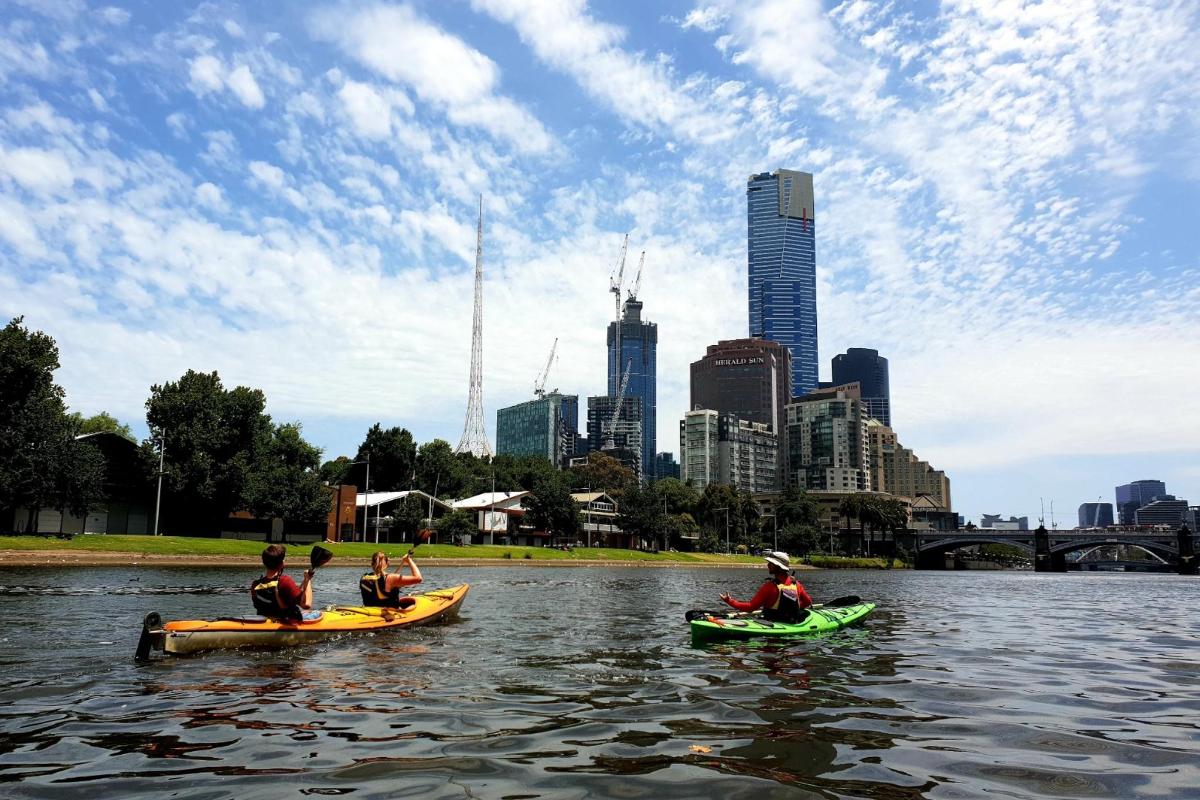 tre persone in kayak sull'acqua in una città
