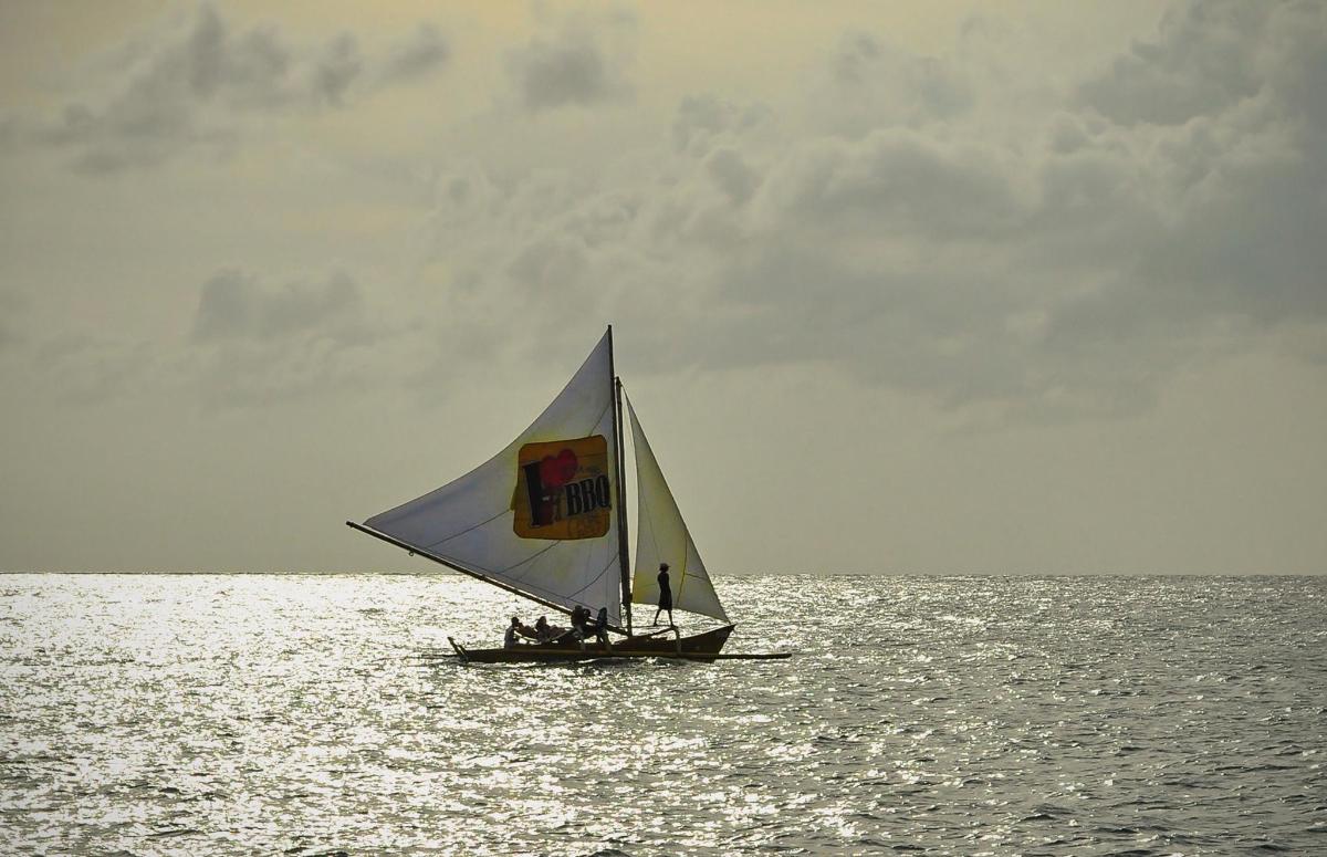 a small boat with a sail in the ocean