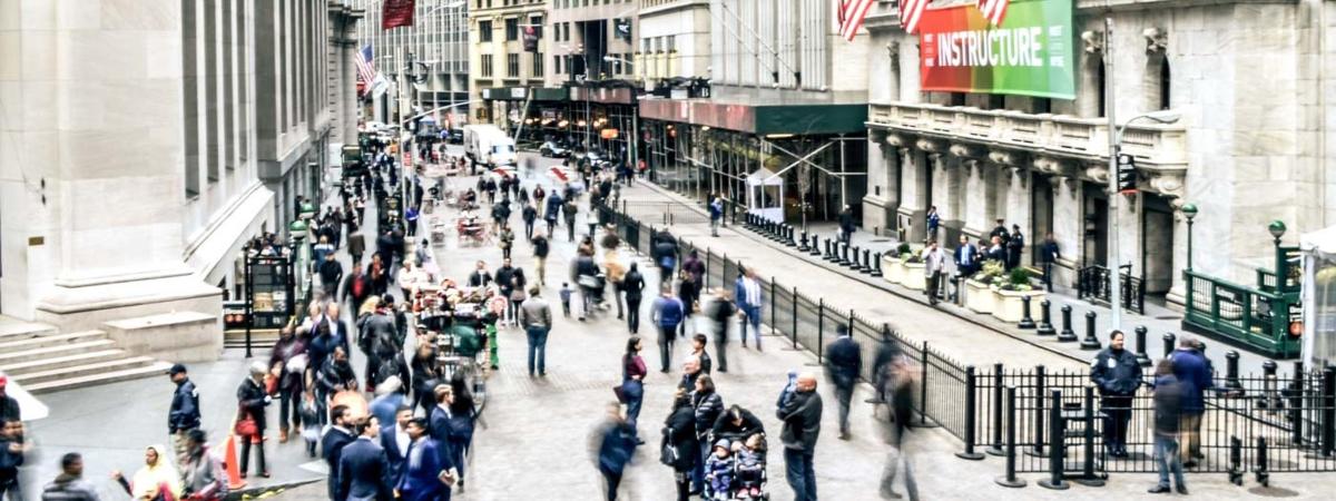 une foule de personnes marchant dans une rue animée de la ville