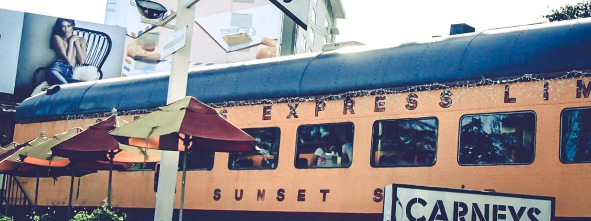 um trem com guarda-chuvas em frente a um prédio