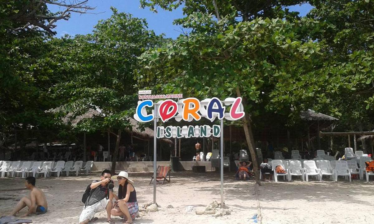 un gruppo di persone su una spiaggia con un cartello