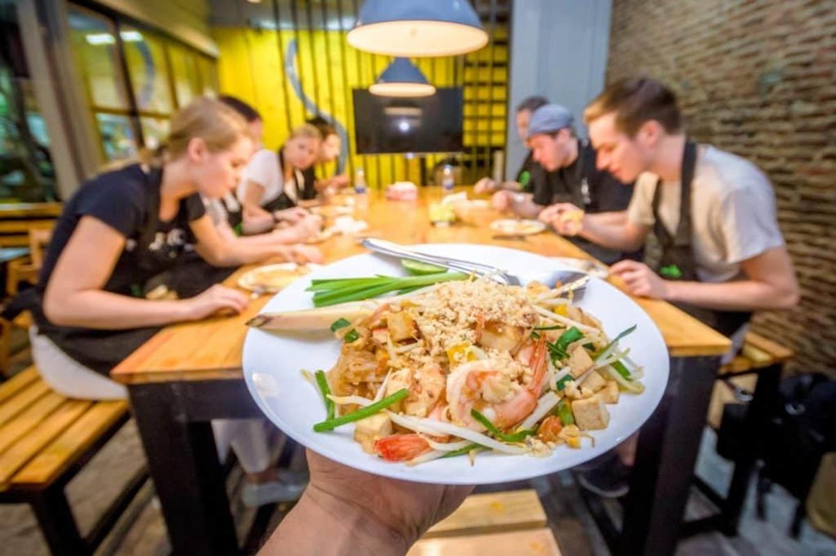 a group of people sitting at a table with a plate of food