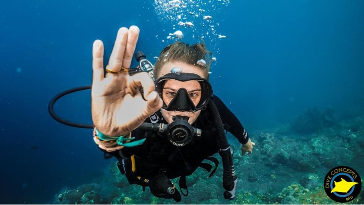 a person in the water holding up a peace sign