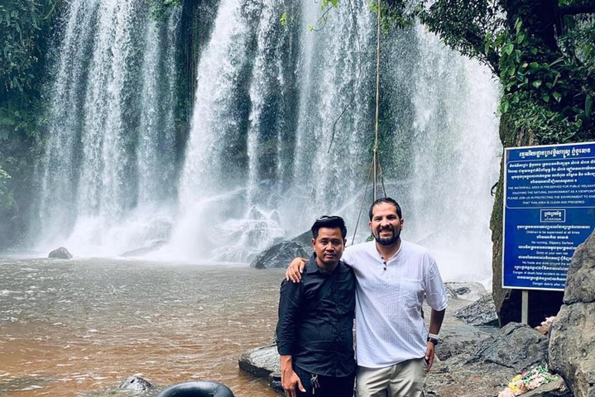 dua lelaki berdiri di hadapan air terjun