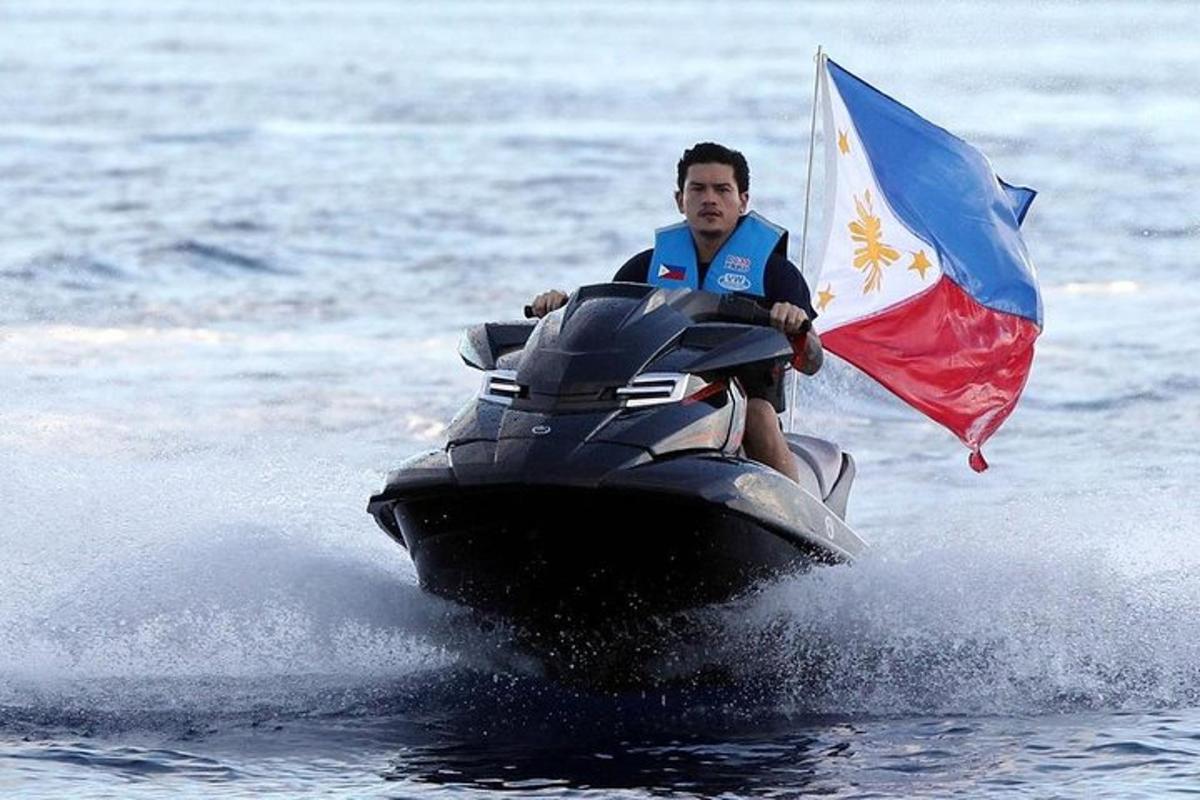 a man riding on a jet ski with a flag