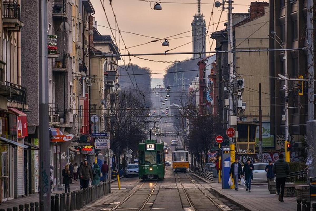 um carrinho verde circulando por uma rua da cidade