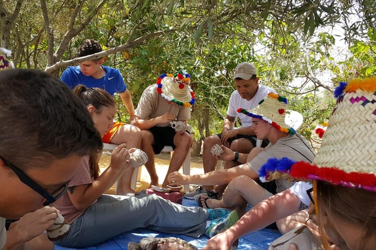 skupina lidí v kloboucích sedících na dece