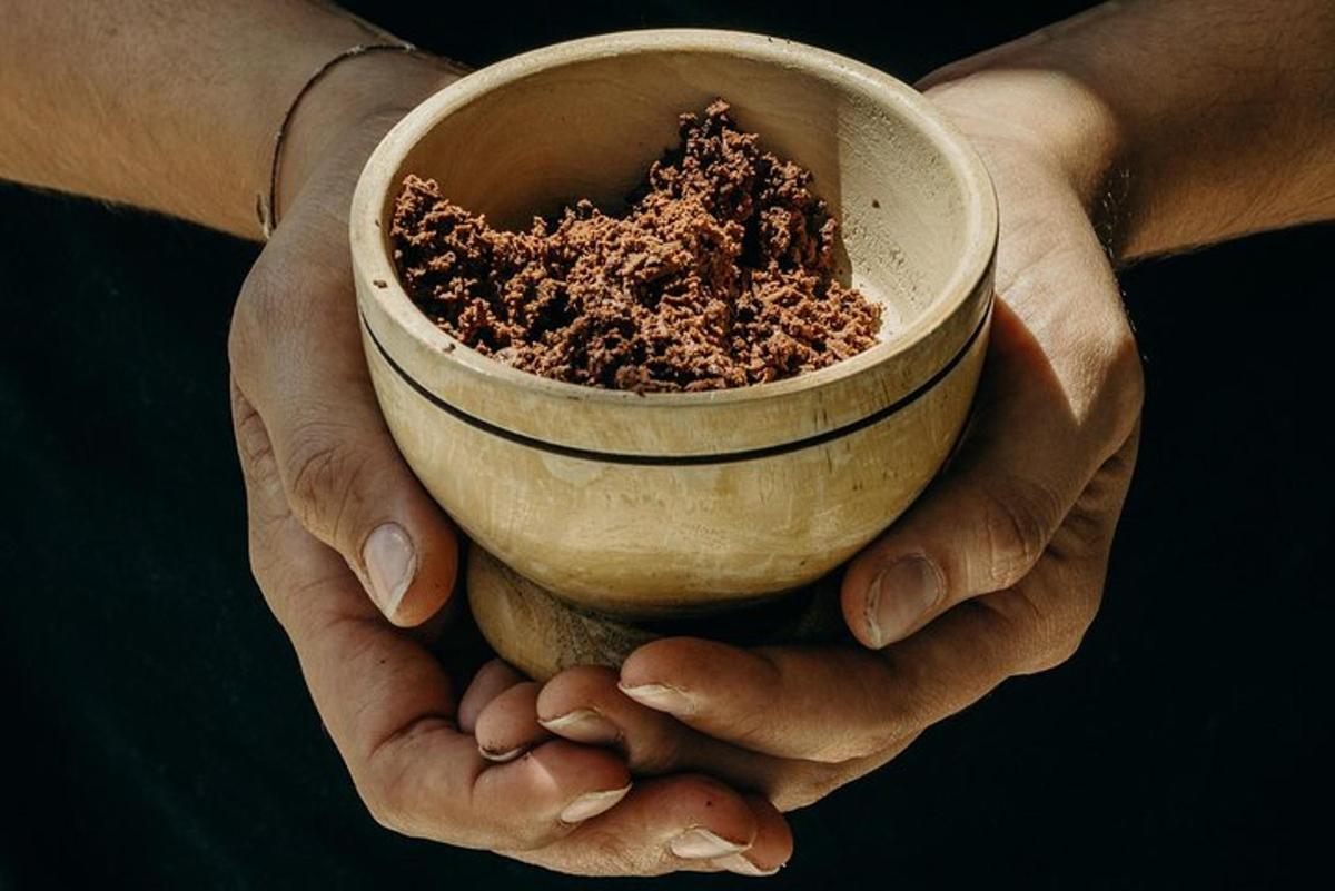 a person holding a bowl of dirt in their hands