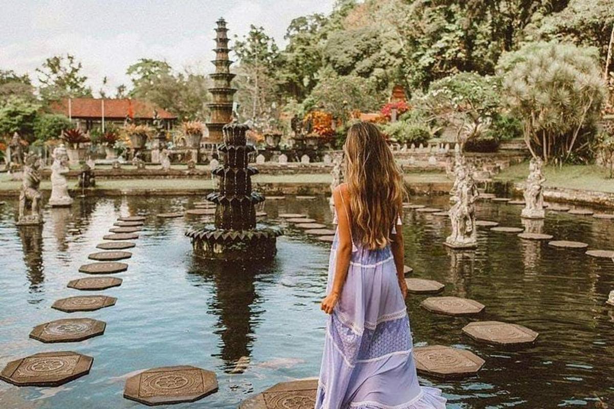 seorang wanita berpakaian berdiri di hadapan air pancut