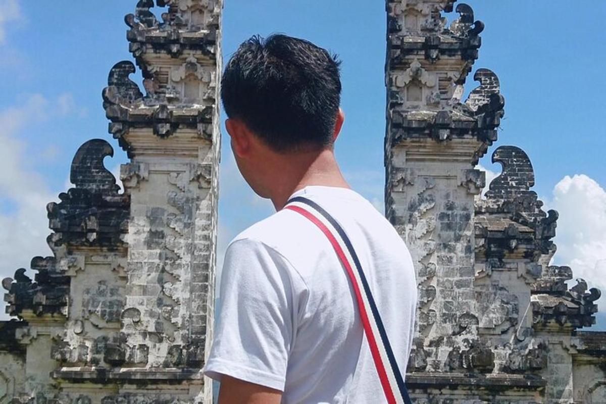 seorang lelaki berdiri di hadapan dua menara batu