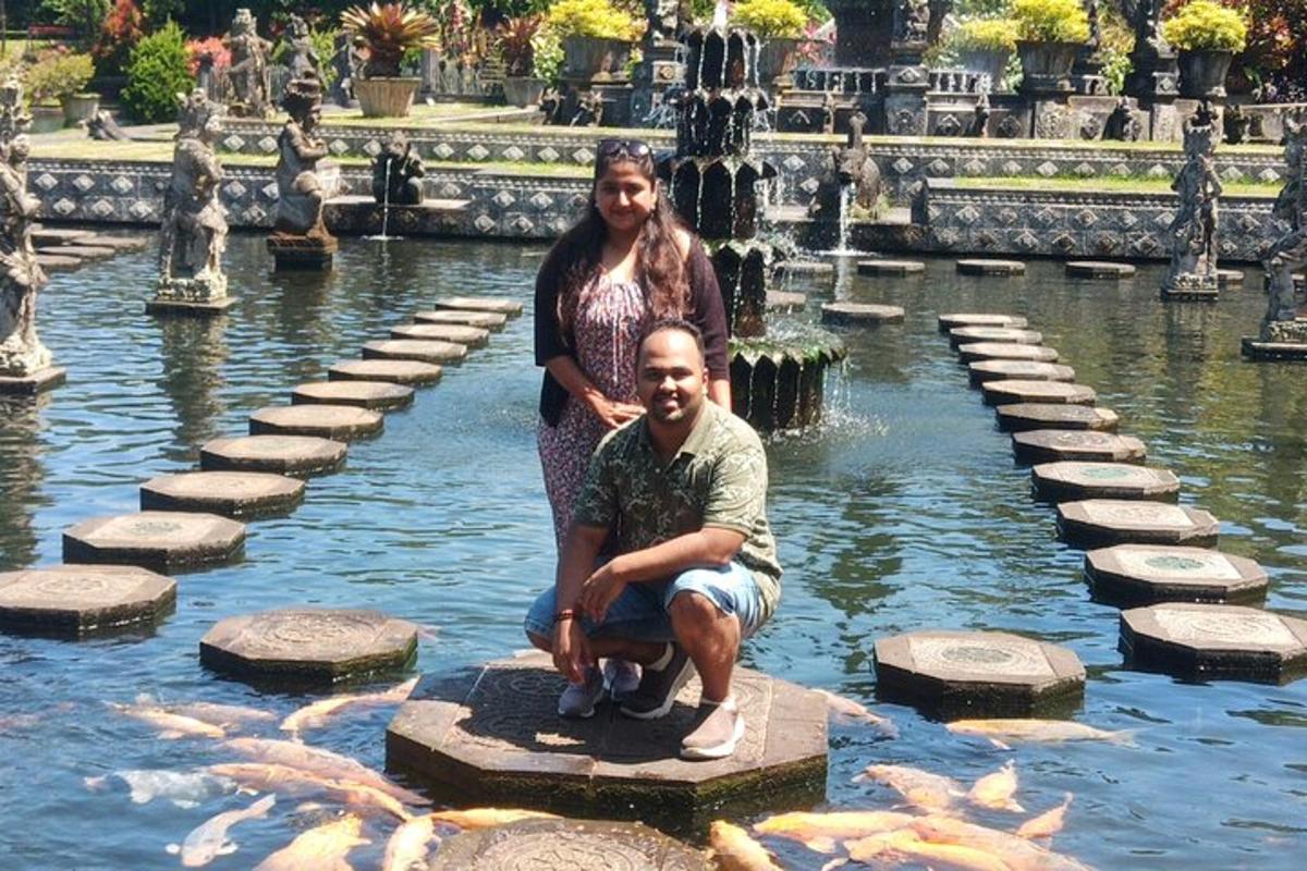 seorang lelaki dan seorang wanita berdiri di dalam kolam dengan ikan