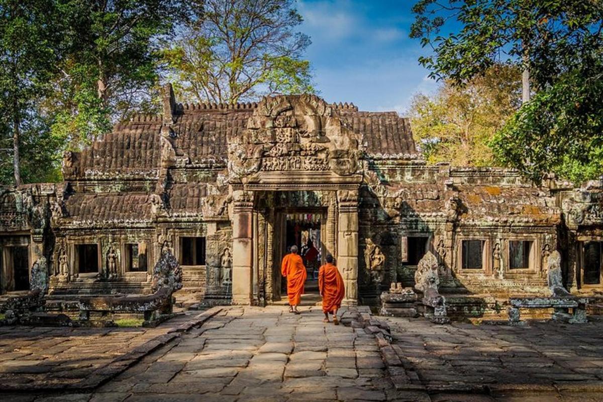 hai người mặc áo choàng màu cam đang bước vào một tòa nhà cổ