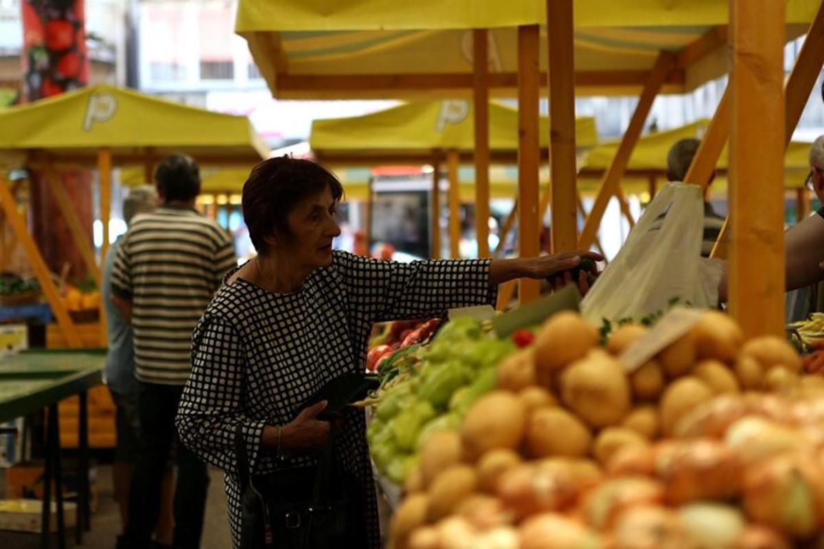 Una mujer sosteniendo una bolsa de compras en un mercado
