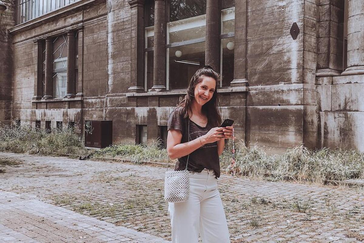 žena držící mobilní telefon před budovou