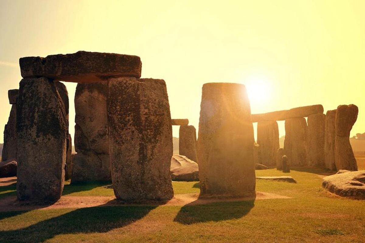 a group of stone structures with the sun in the background