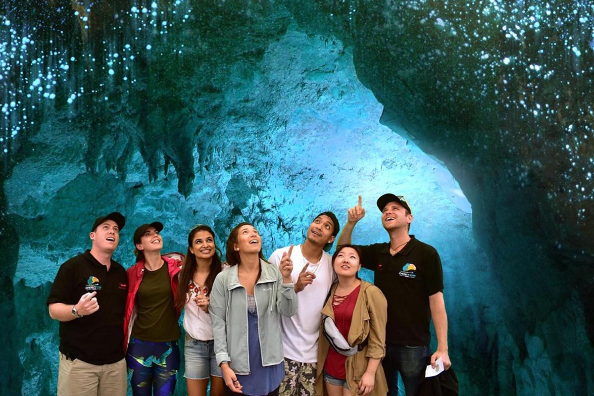 a group of people standing in front of a cave