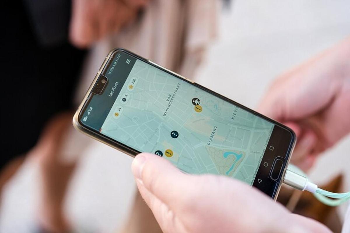 osoba držící mobilní telefon s mapou