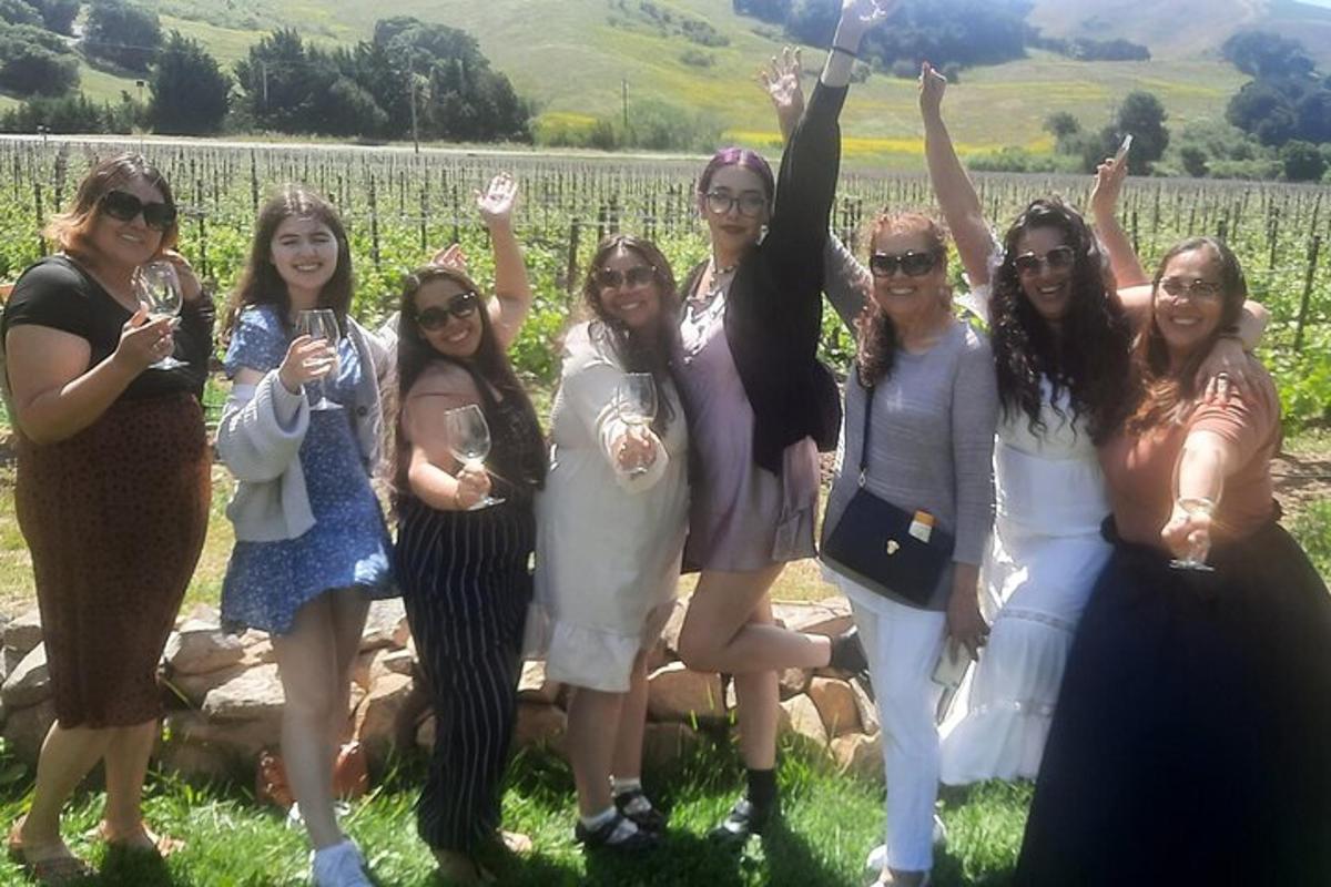 un gruppo di donne in posa per una foto davanti a un vigneto