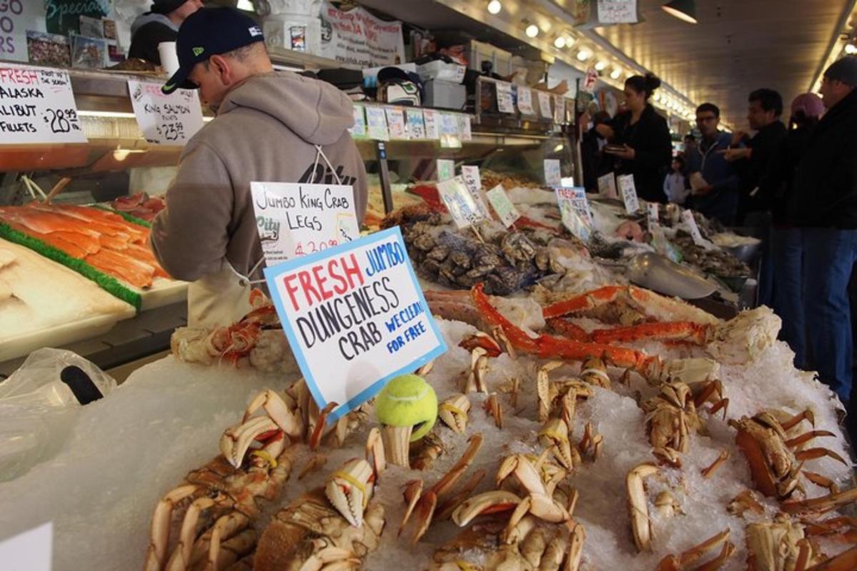 um homem em pé em um mercado com frutos do mar em exposição