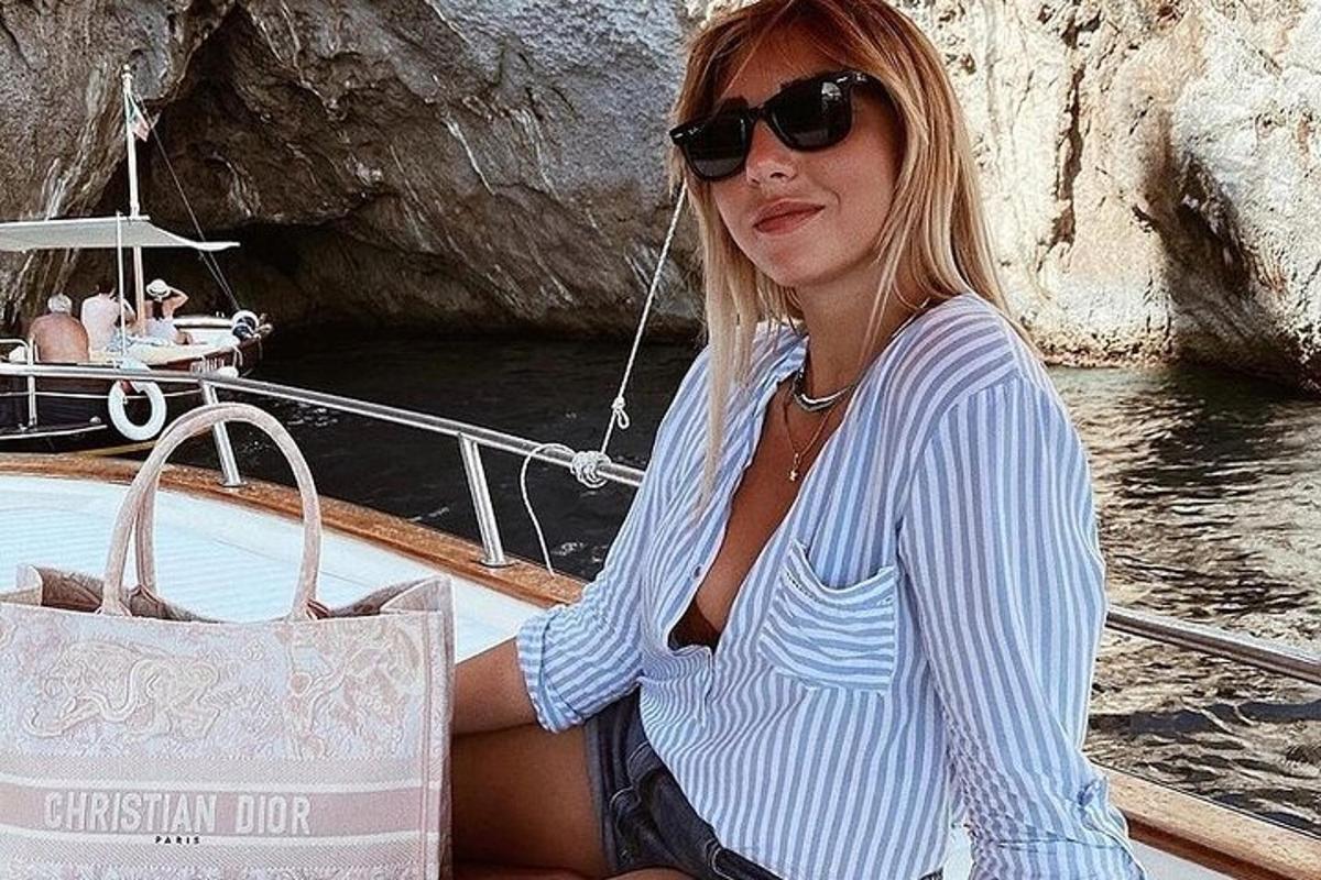 žena sedící na lodi s kabelkou