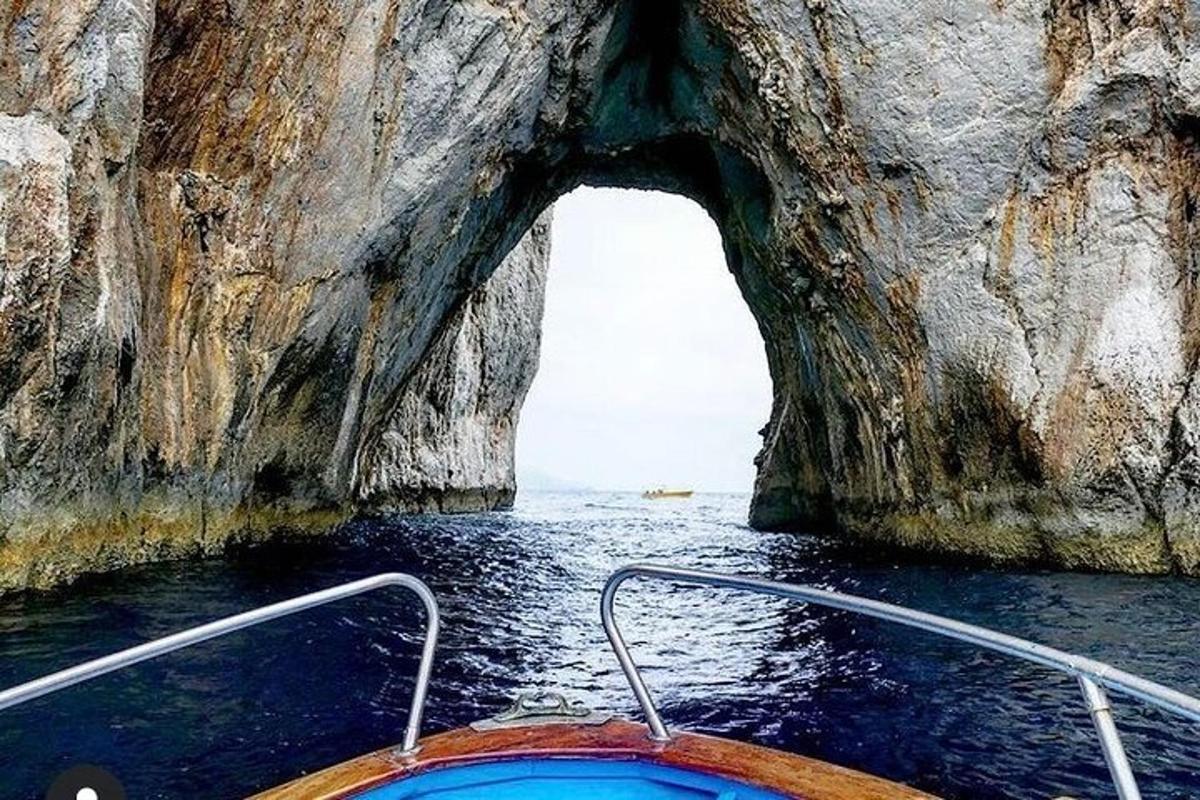 Un barco frente a una cueva en el agua.