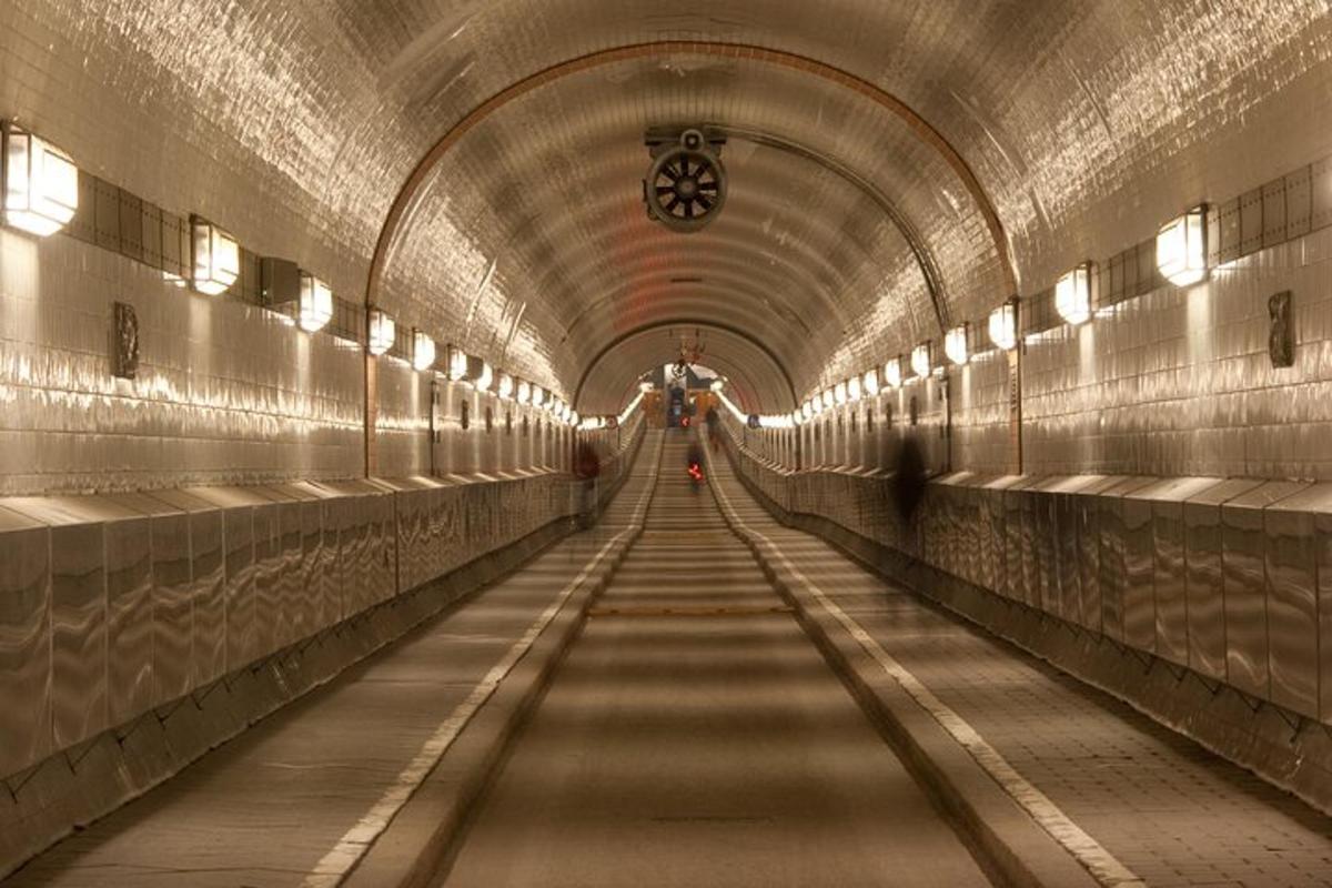 een lange gang in een tunnel met een persoon die er doorheen loopt