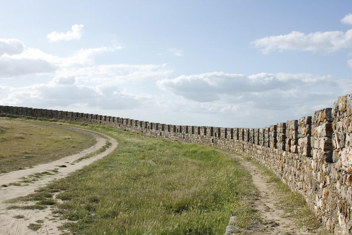 un muro di pietra accanto a una strada sterrata