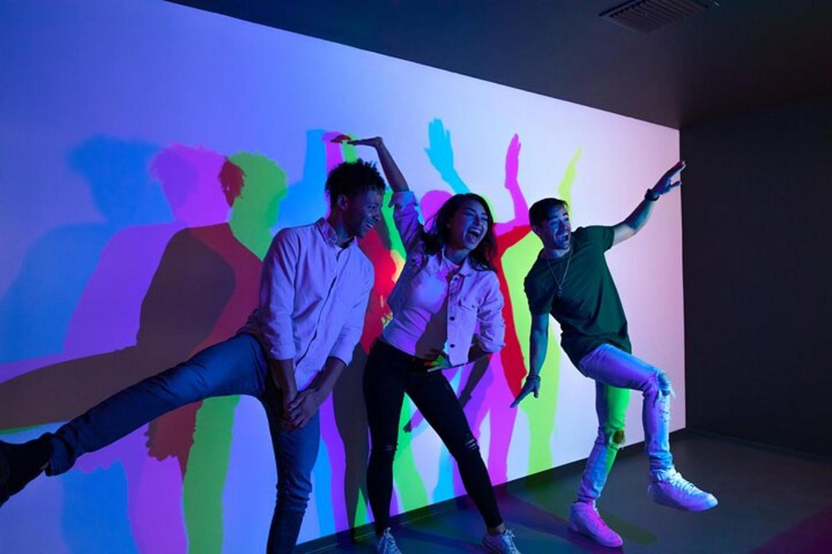 a group of people dancing in front of a colorful wall