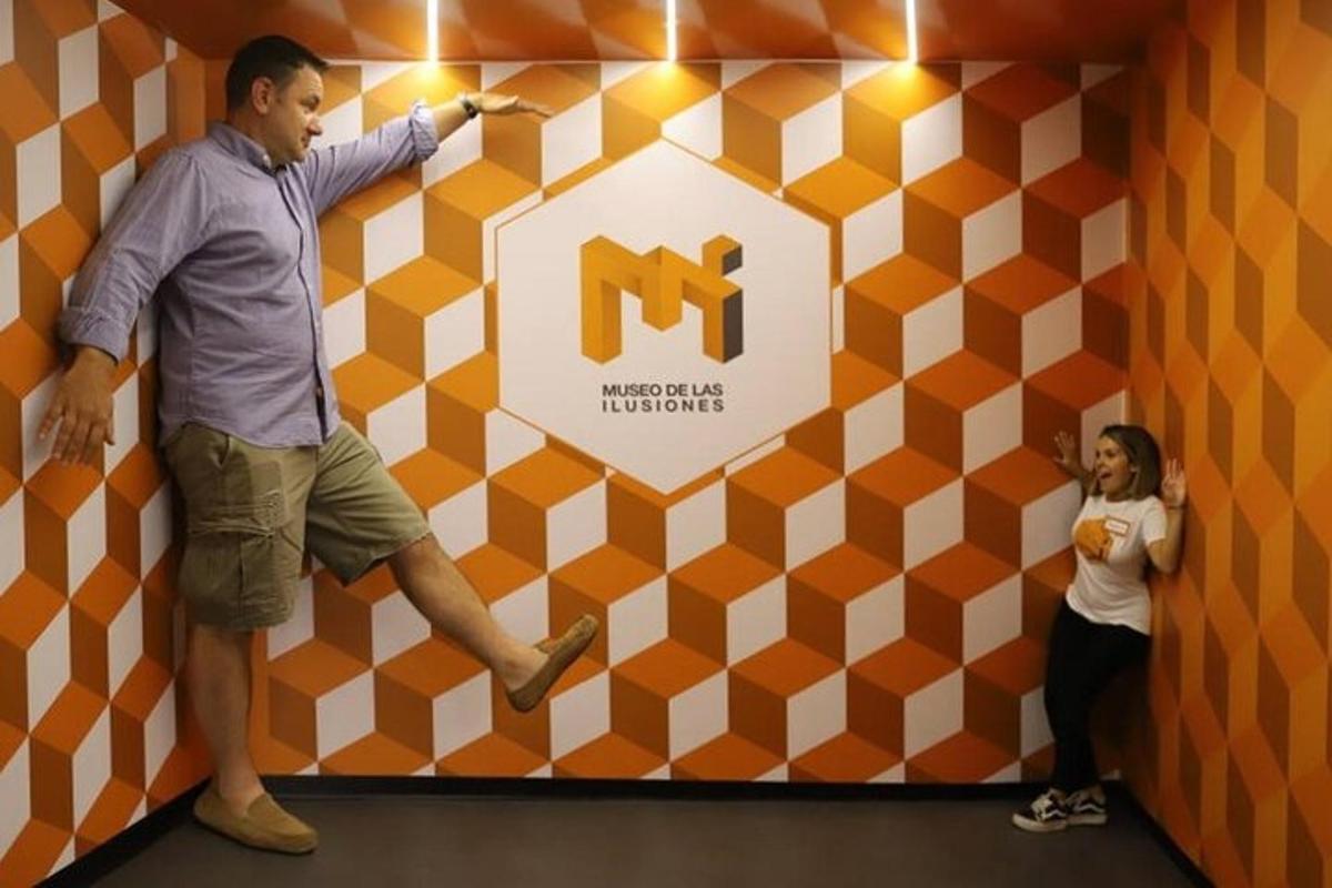 a man and a woman standing next to a wall with a sign
