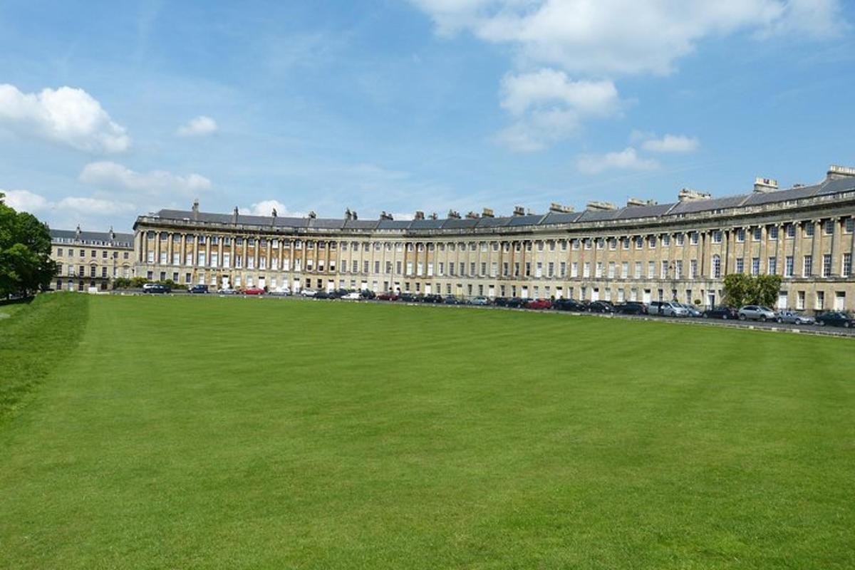 Un gran edificio con un campo verde delante.