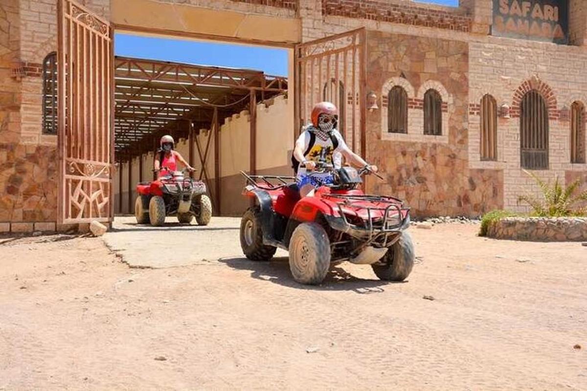 un uomo in sella a un quad davanti a un edificio