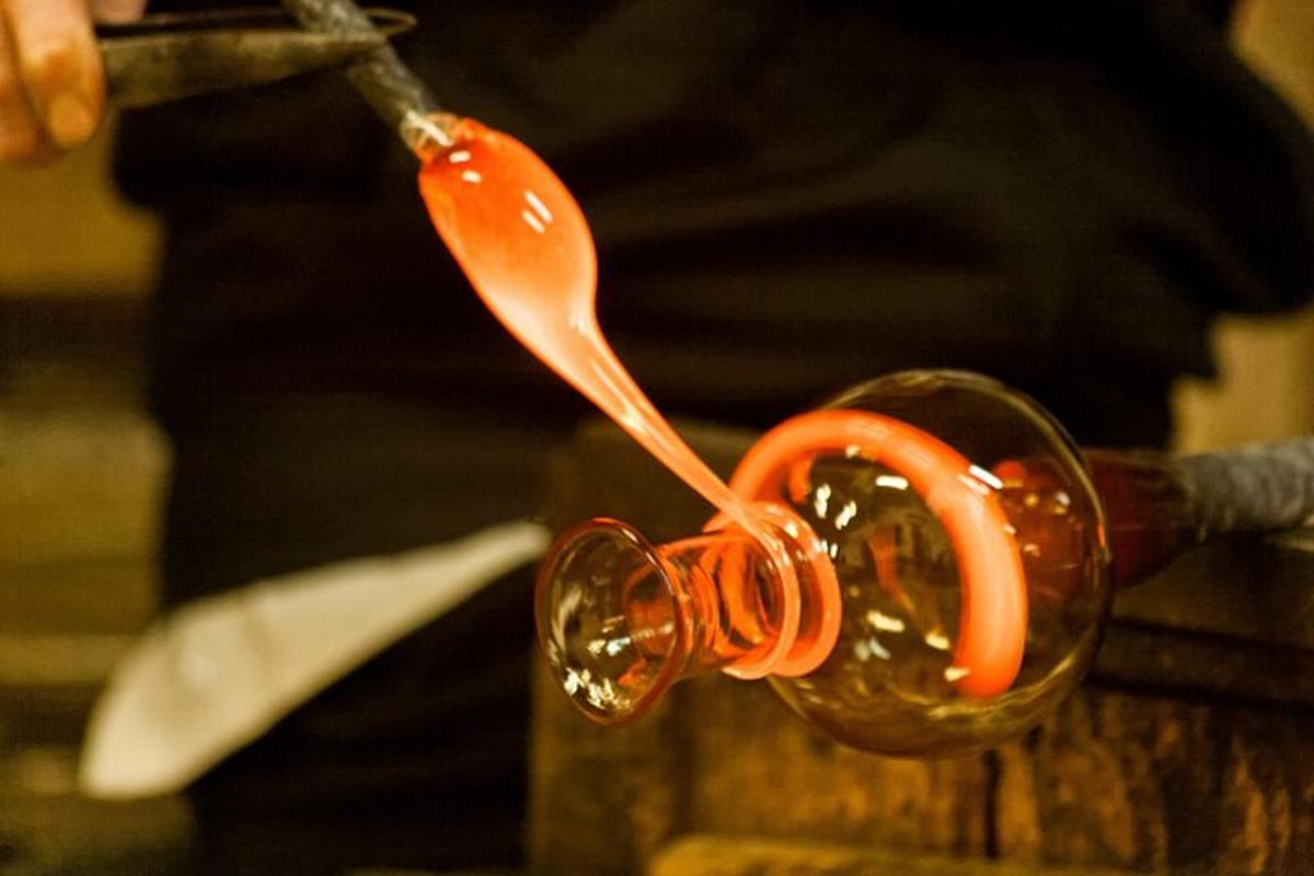 a person pouring sauce into a wine glass