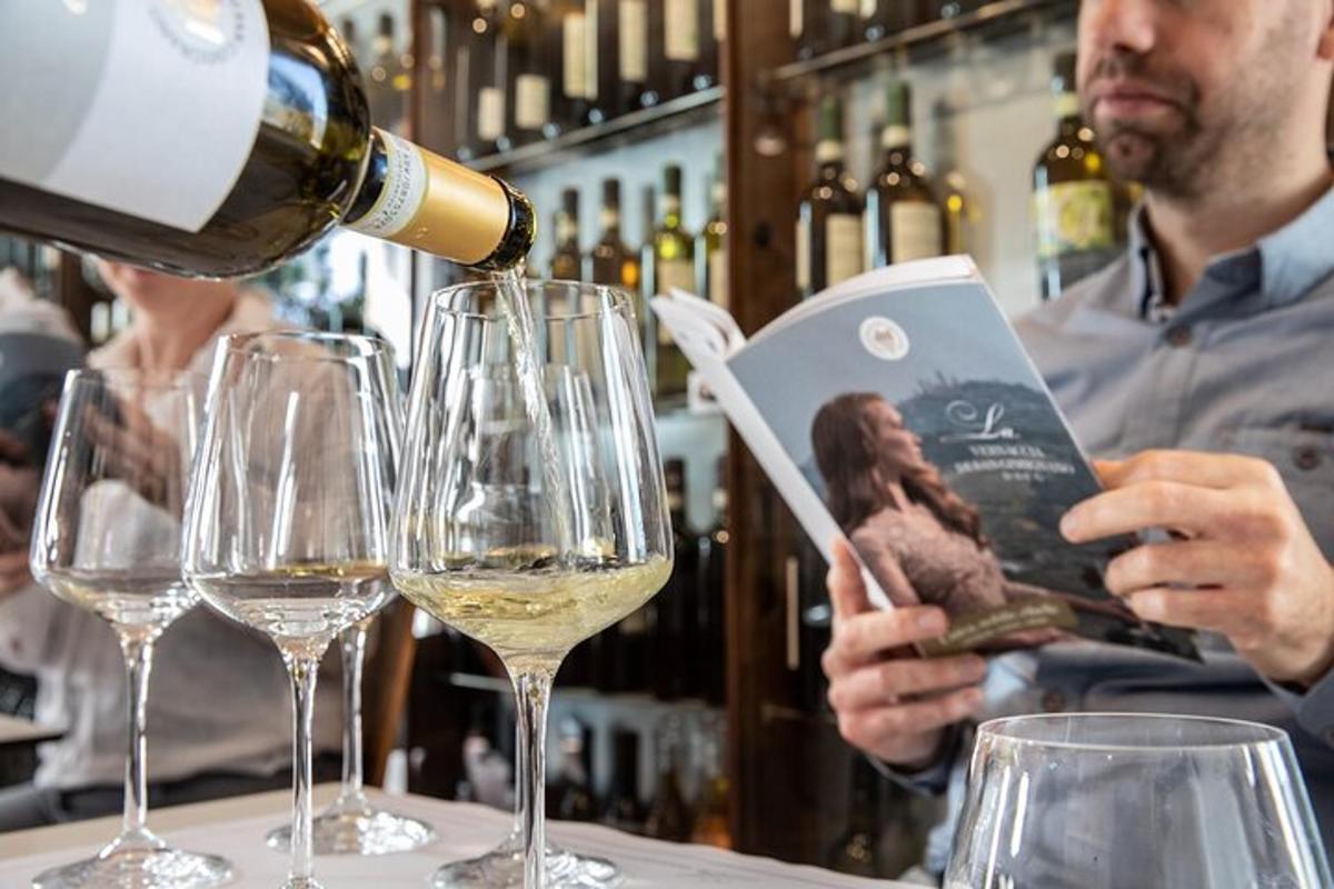 moški, ki naliva belo vino v kozarce za vino