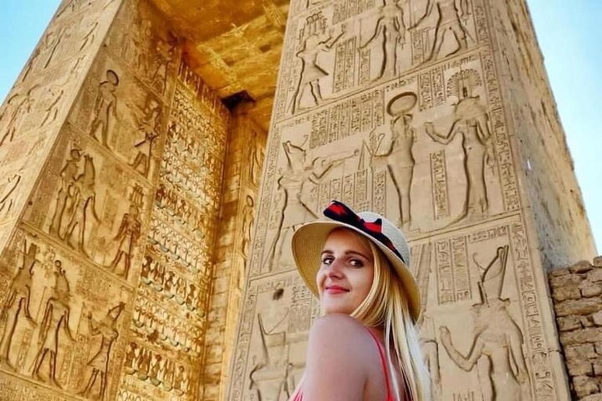 una donna con un cappello in piedi davanti a un muro
