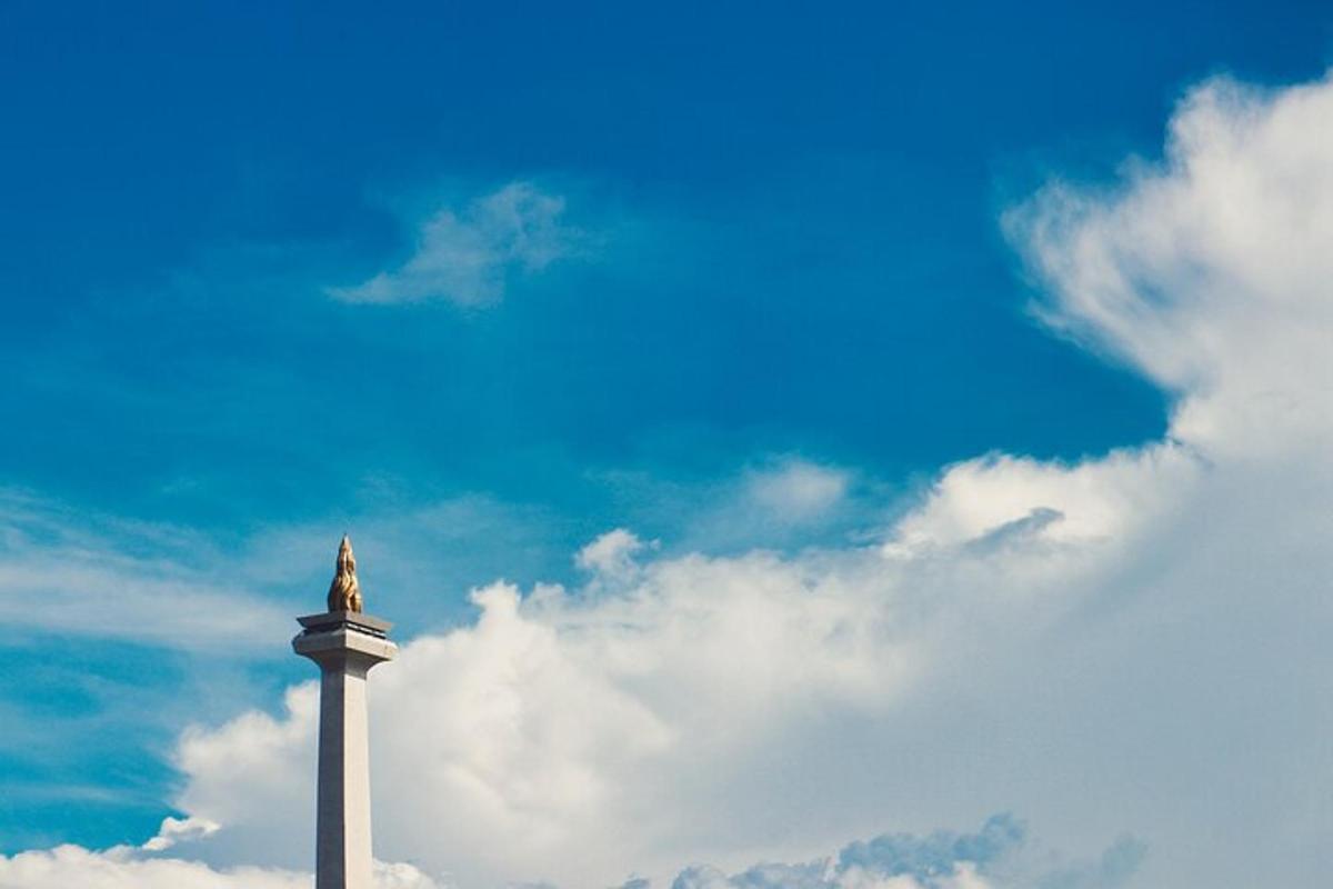 a statue on top of a tower against a cloudy sky