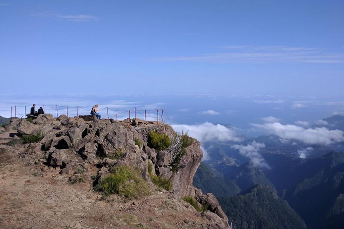 dua orang duduk di puncak gunung