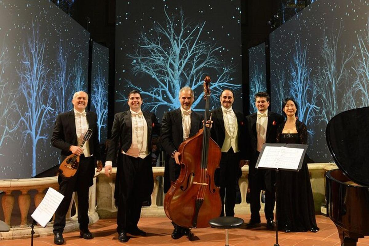 a group of people posing for a picture with a cello