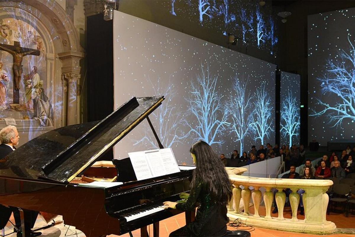 a woman playing a piano in front of a stage