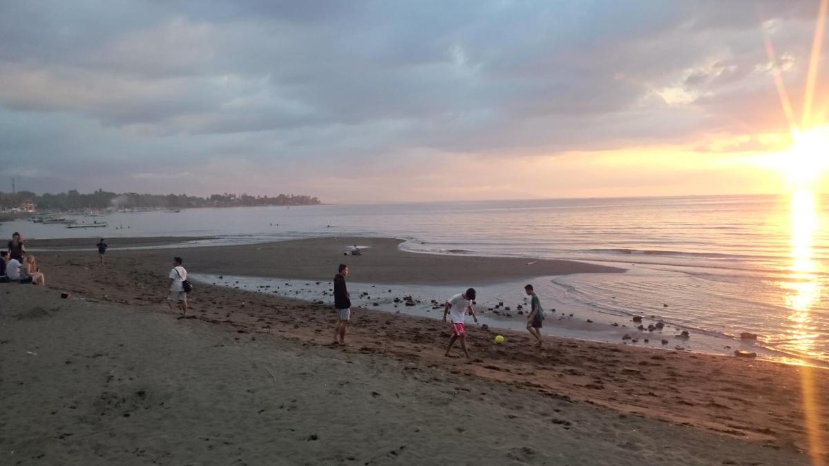un grupo de personas en la playa al atardecer