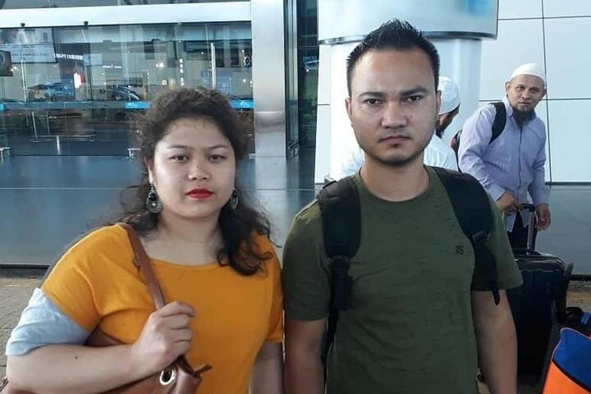 a man and a woman standing in an airport