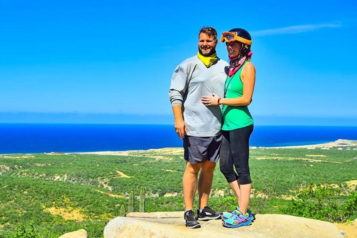 um homem e uma mulher em pé no topo de uma rocha