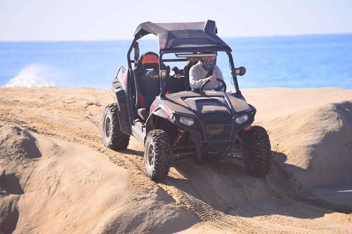 un uomo alla guida di un quad sulla spiaggia