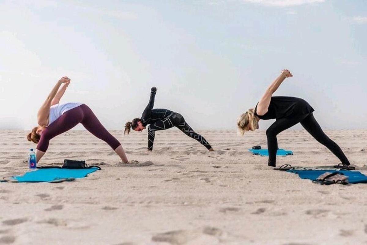 a group of women doing yoga on the beach