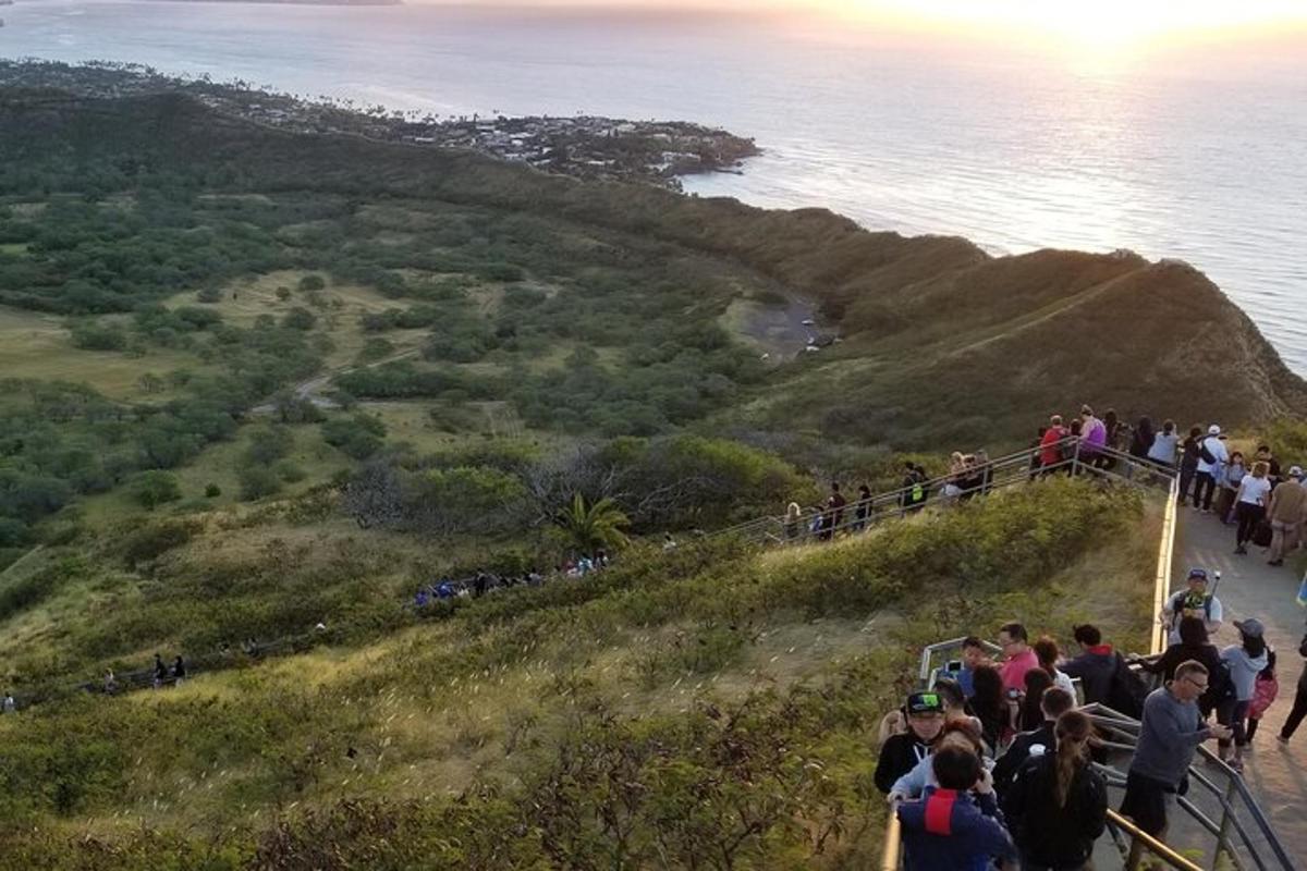 a group of people standing on a hill near the ocean