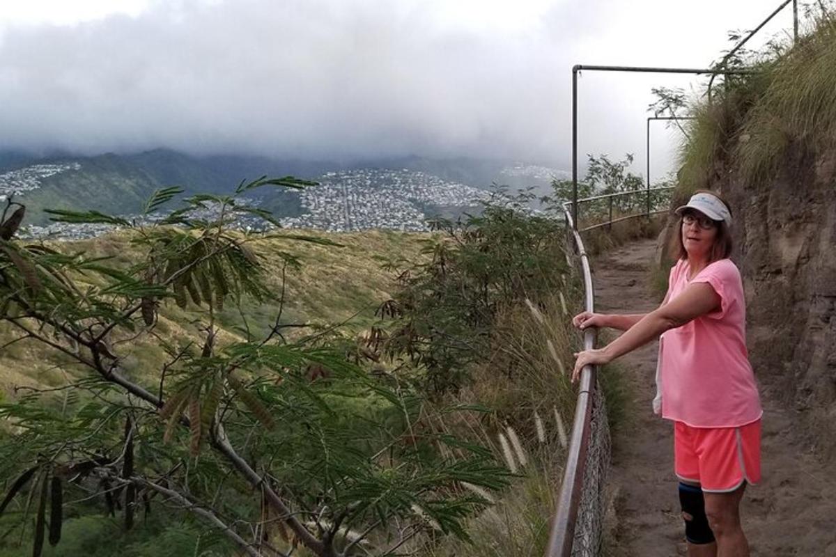 a woman standing on a path on a mountain