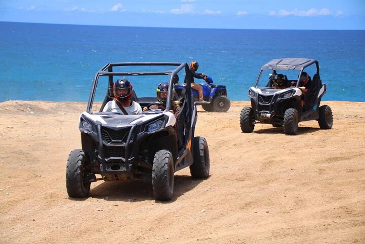 dve osebi, ki se vozita s štirikolesniki na plaži