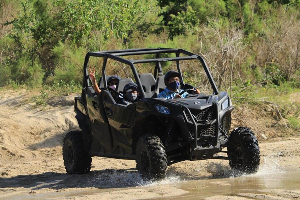 a group of people riding in a jeep in the mud