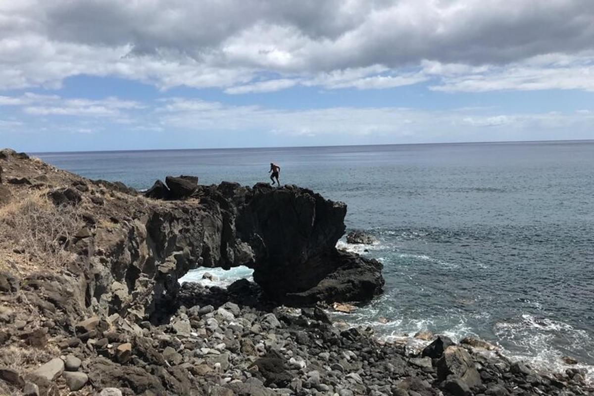 una persona in piedi su una roccia vicino all'oceano