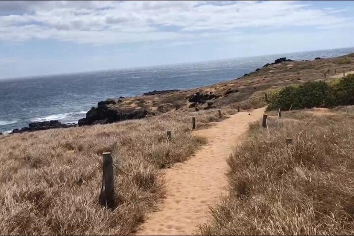 un sentiero sterrato su una collina vicino all'oceano