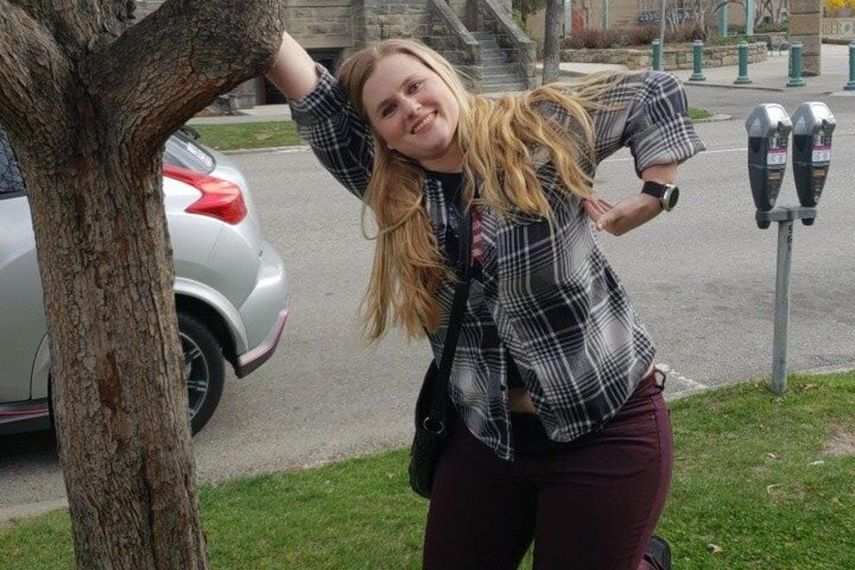 žena stojící vedle parkovacího automatu